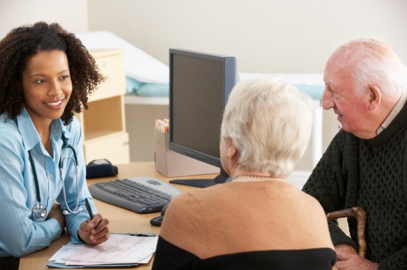 Young female Doctor talking to senior couple